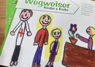 Eine Broschüre mit dem Titel „Wegweiser Kinder & Krebs“ mit einer Kinderzeichnung von drei Figuren und einer Pflanze im Topf. Das Cover ist von LAGO Hilfe bei Krebs.