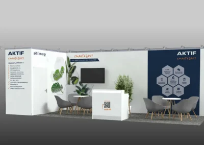 Ein Messestand mit Sitzgelegenheiten, Pflanzen und einem Fernseher an der Wand. Das Firmenbranding umfasst „Aktif“ und ein sechseckiges Design.