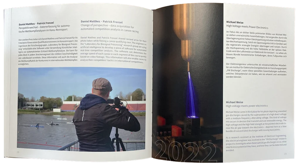 Eine Person in einer blauen Jacke benutzt eine Kamera auf einem Stativ neben einem Fluss, mit Sportplätzen und einem Stadion im Hintergrund; auf der rechten Seite erscheint eine Nahaufnahme eines blauen Lichtbogens über der Jahreszahl "2022".